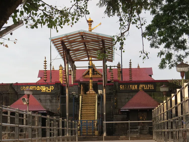 The gold-plated Pathinettampadi, the eighteen holy steps, rising under a canopy to the Sabarimala sanctum with Saranam Ayyappa lettered on the wall